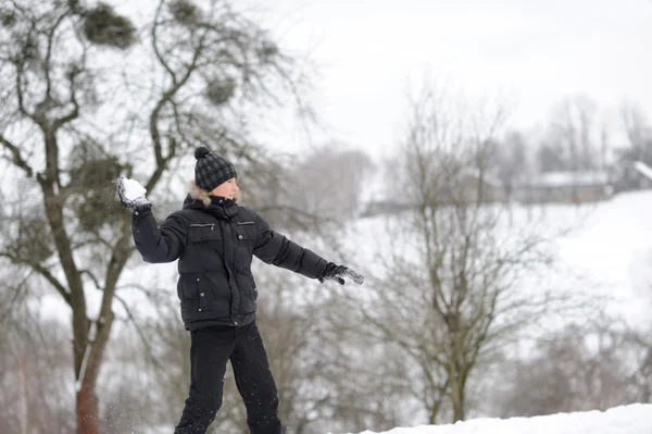 Chico lanzando bolas de nieve — Foto de Stock