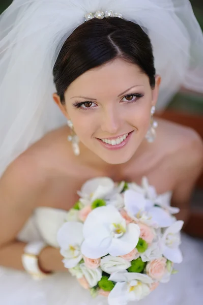 Gelukkig lachend bruid met boeket van bloemen — Stockfoto