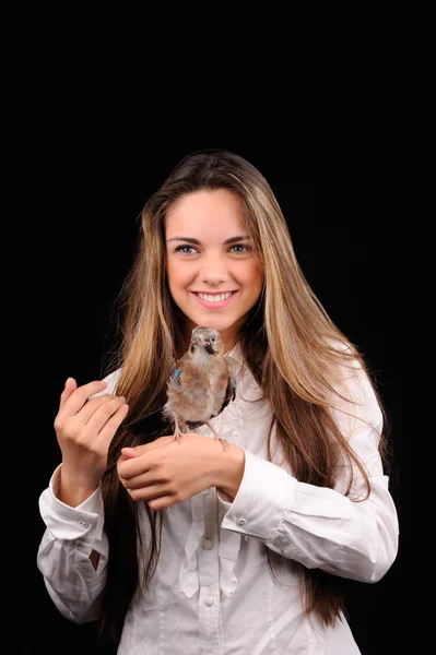 Retrato de niña sonriente con pájaro en la mano — Foto de Stock