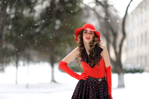 Attraente ragazza in cappello rosso all'aperto sulla neve — Foto Stock