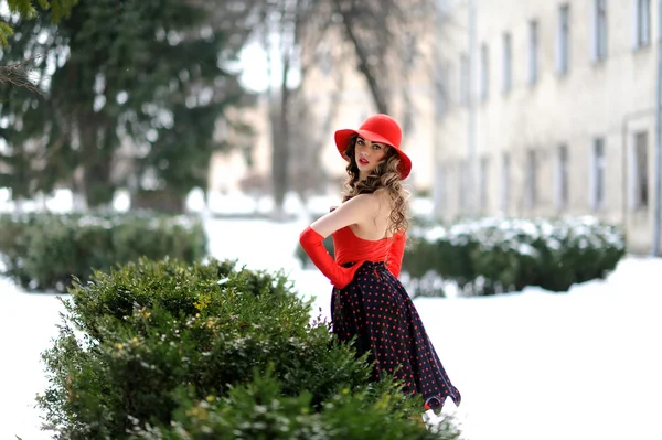 Attractive girl in red hat outdoor on the snow — Stock Photo, Image