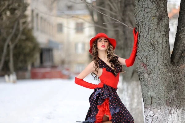 Привлекательная девушка в красной шляпе на открытом воздухе на снегу — стоковое фото