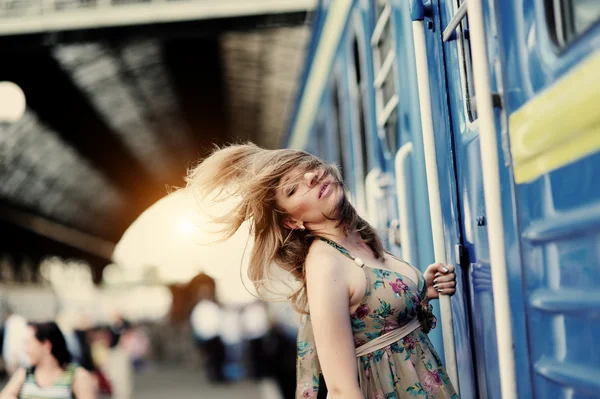 Ragazza con i capelli fluenti vicino al treno — Foto Stock