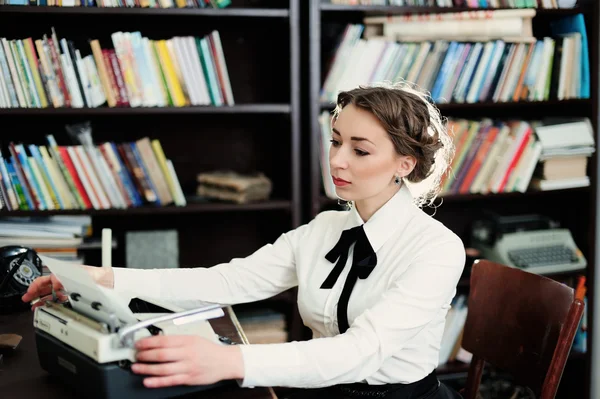 Uma jovem mulher na biblioteca — Fotografia de Stock