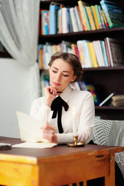 Uma jovem mulher na biblioteca — Fotografia de Stock