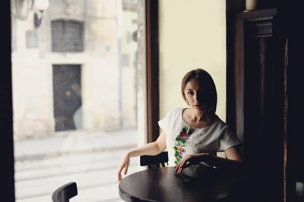 Ładny dziewczyna siedzi w kawiarni — Zdjęcie stockowe