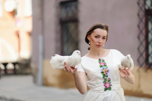 可爱的女孩与鸽子在摆在城市街道上的手 — 图库照片
