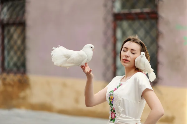 Jolie fille avec colombe dans la main posant sur une rue de la ville — Photo