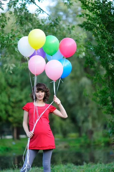 Happy young pregnant woman with balloons in the hands Stock Image