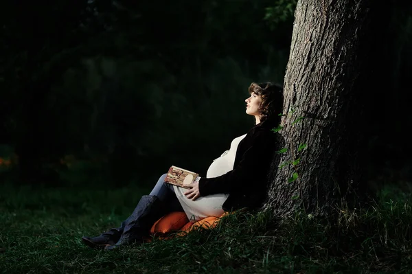 Felice giovane donna incinta leggendo un libro — Foto Stock