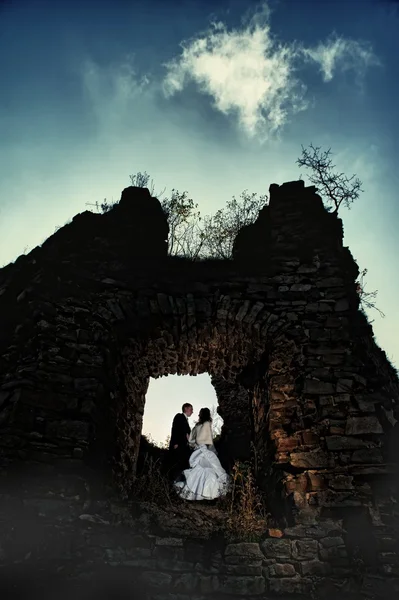 Braut und Bräutigam küssen sich im alten Schloss — Stockfoto