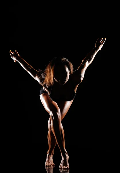 Mooie vrouwelijke lichaam op een donkere achtergrond — Stockfoto