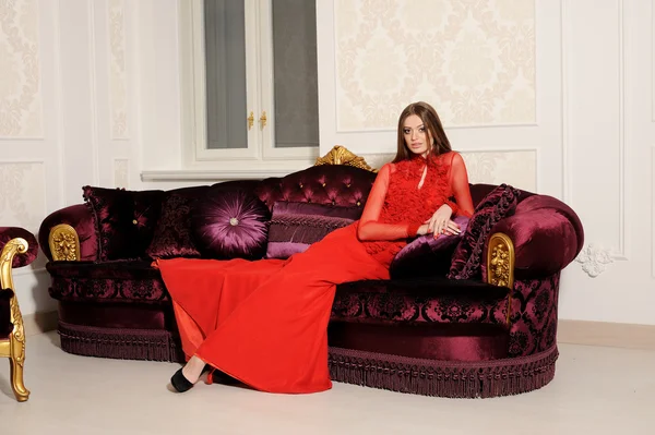 Приваблива жінка розслабляється на дивані в розкішному інтер'єрі — стокове фото