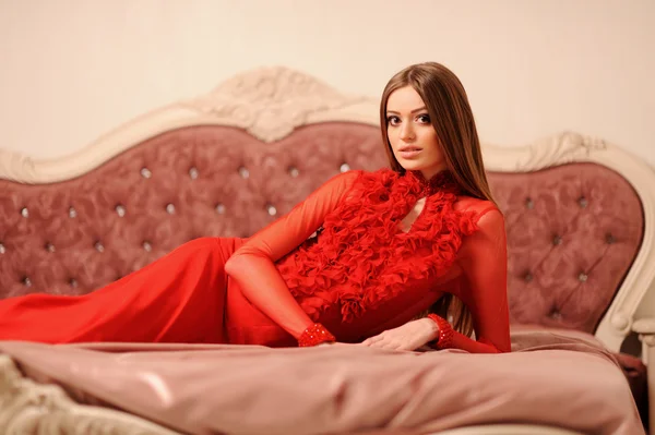 Seducente donna rilassante su un divano in interni di lusso — Foto Stock