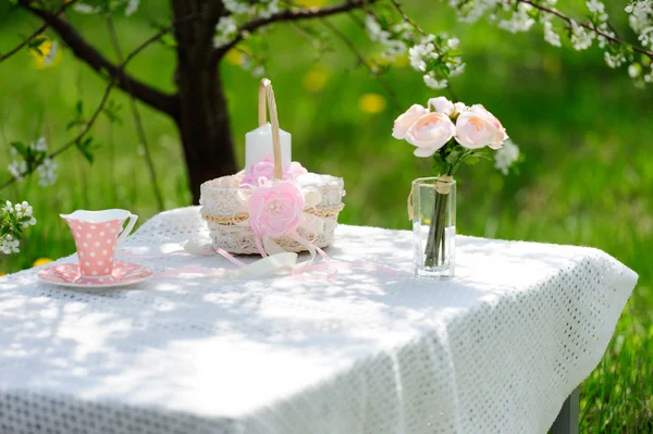 Bouquet of roses and  cup on the table in the garden — Stock Photo, Image