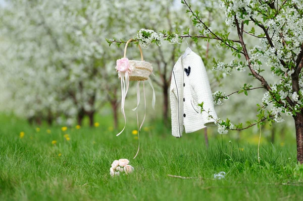 Manteau blanc, panier et bouquet dans le jardin — Photo