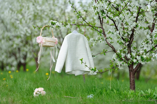 White coat, basket and bouquet in garden — Stock Photo, Image