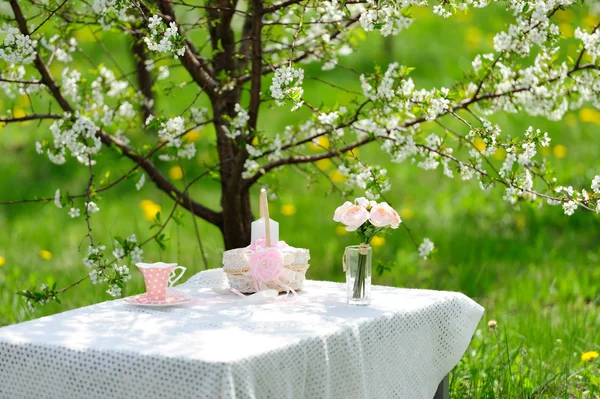 Букет роз и чашки на столе в саду — стоковое фото