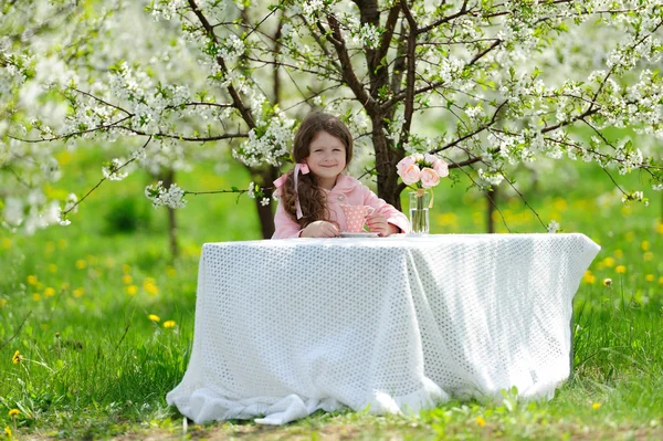 Маленькая красивая девочка в зеленом саду — стоковое фото