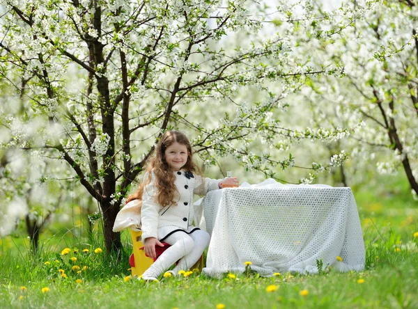 Маленькая красивая девочка в зеленом саду — стоковое фото