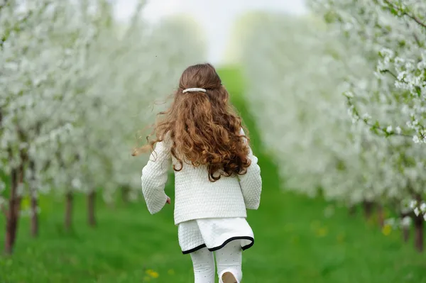 Kleines Mädchen läuft im Garten — Stockfoto