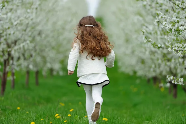 Little girl running in the garden — Stock Photo, Image