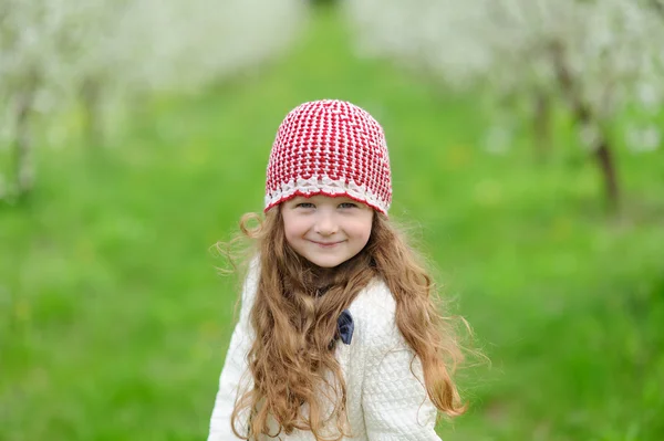 Kleines hübsches Mädchen im grünen Garten — Stockfoto