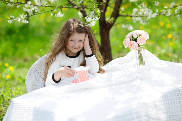 Kleines hübsches Mädchen im grünen Garten — Stockfoto