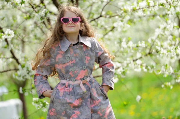 Pequena menina bonita no jardim verde — Fotografia de Stock