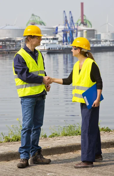 Zwei Hafenarbeiter beim Händeschütteln — Stockfoto