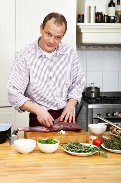 Uomo che prepara la carne al bancone della cucina — Foto Stock