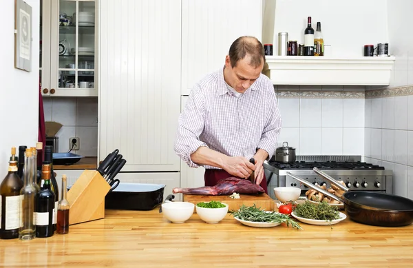 Man skära kött på skärbräda — Stockfoto