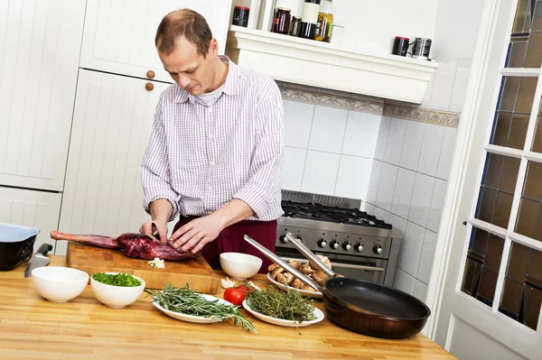 Man voorbereiding van vlees in keuken — Stockfoto