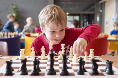 Young chess player at a tournament clipart