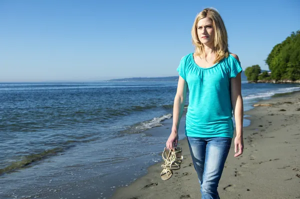 Jeune femme marchant sur la plage — Photo