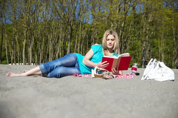 Młoda kobieta, czytanie książki na plaży — Zdjęcie stockowe