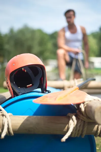 Helmet and oar on inflatable raft — Stock Photo, Image