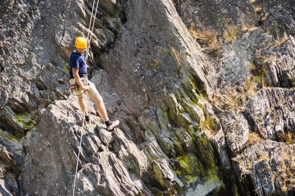 Hombre joven escalando roca — Foto de Stock