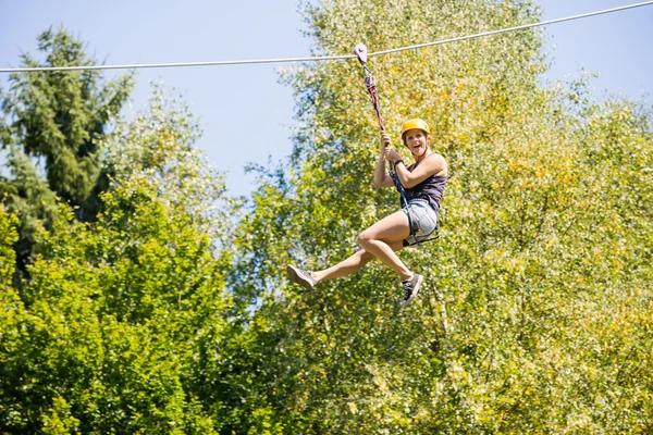 Happy Woman Hanging on Zip Line in Forest — стоковое фото