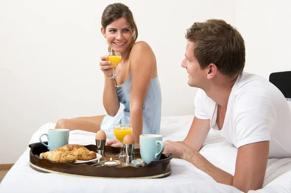 Pareja con desayuno en la cama — Foto de Stock