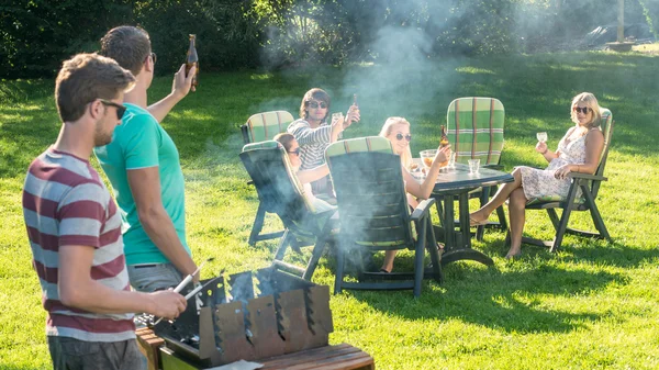 Vrienden genieten van barbecue in de tuin — Stockfoto