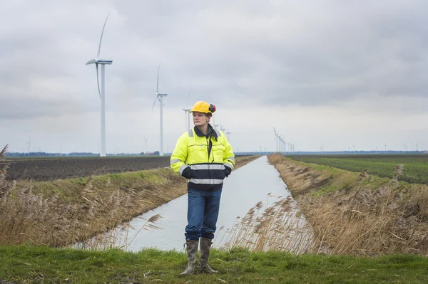 Projektutvecklare i ett lummigt landskap med väderkvarnar — Stockfoto