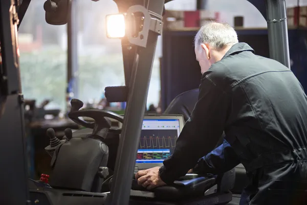 Mechanic met heftruck van elektronica en motor — Stockfoto