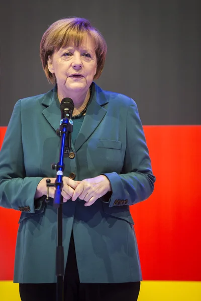 Angela merkel hält eine rede vor der deutschen fahne — Stockfoto