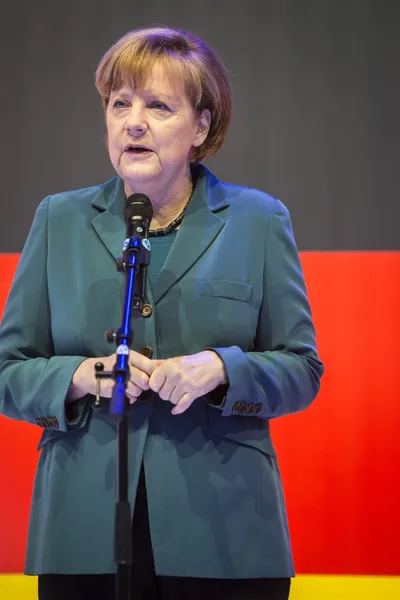 Angela Merkel dando un discurso frente a la bandera alemana — Foto de Stock