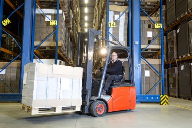 depolama rafları önünde forklift