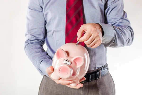 Business man holding a pig bank - economy savings Stock Photo