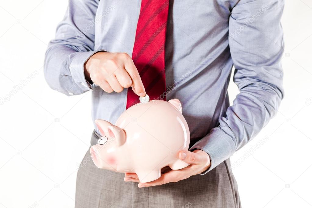 Business man holding a pig bank - economy savings