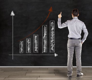 trend iş grafik sunmak bir karatahta önünde genç iş adamı