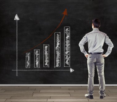 trend iş grafik sunmak bir karatahta önünde genç iş adamı